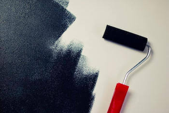 Catalyst Painting roller applying a fresh coat on a Kansas City home